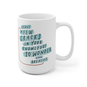 Inspiring quote about wonder and creativity printed on 15 oz white coffee mug decorated with abstract shapes.