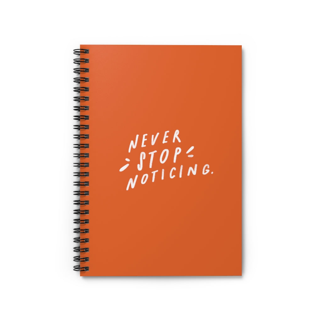 Bright orange 6” x 8” spiral notebook with hand-lettered quote about mindfulness on the cover.