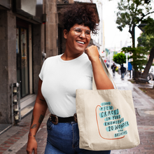 Load image into Gallery viewer, Smiling woman walking down a street holding a tote bag with inspirational quote about knowledge and wonder.
